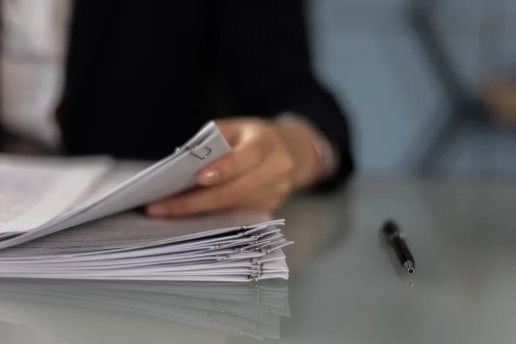 Fogli di un contratto appoggiati su un piano chiaro