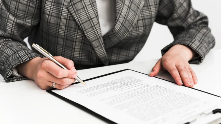 Un documento con una firma in calce, appoggiato su una scrivania