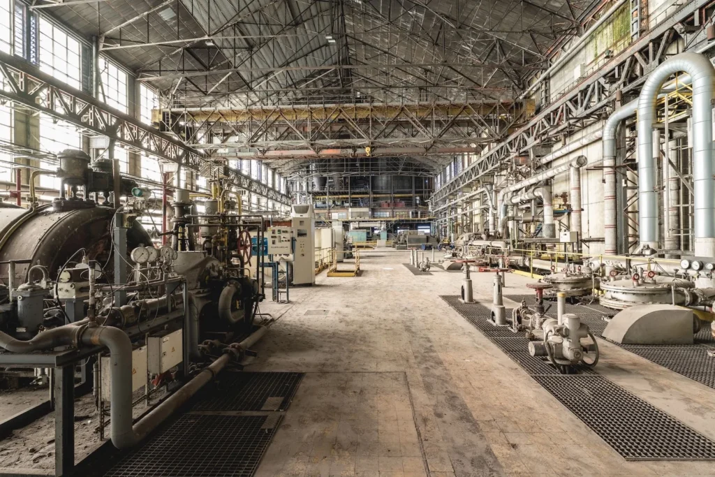 L interno vuoto di un capannone industriale, con le strutture metalliche del tetto in vista